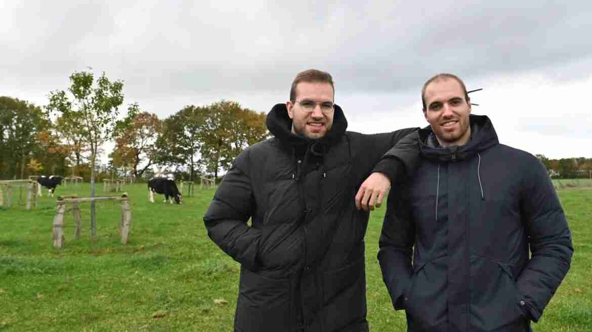 Marco und Maik Möller stehen auf der Weide. Im Hintergrund erkennt man zwei Kühe und eine Streuobstwiese.