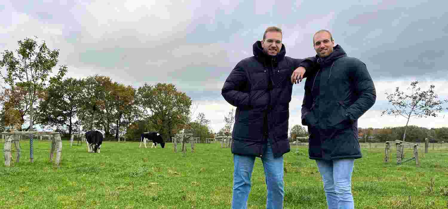 Marco und Maik Möller stehen auf der Weide. Im Hintergrund erkennt man zwei Kühe und eine Streuobstwiese.