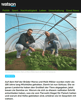 Marco und Maik Möller hocken im Folientunnel zwischen  bio-veganem Gemüse. Vor Ihnen steht ein Schild mit dem Logo von Möllers Morgen.