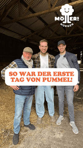 Drei lächelnde Männer stehen gemeinsam in einem Stall von Möllers Morgen, über ihnen der Text So war der erste Tag von Pummel!