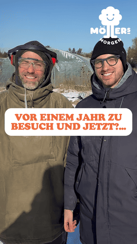 Zwei lächelnde Männer von Möllers Morgen – einer mit Schutzbrille und Gehörschutz, der andere mit schwarzer Mütze – vor einem Gewächshaus, Textüberlagerung lautet: "Vor einem Jahr zu Besuch und jetzt?...".